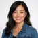 A photorealistic avatar portrait of a diverse adult in a professional headshot style, featuring a warm smile and direct gaze,